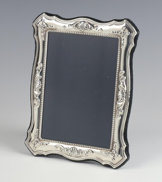 A modern repousse silver photograph frame decorated with scrolls 18cm x 13cm 