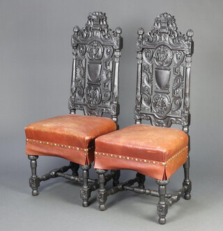 A pair of ebonised Carolean style pierced and carved high back hall chairs, the seats upholstered in brown leather, raised on turned and block supports 120cm h x 51cm w x 47cm d (seat 34cm x 30cm) 