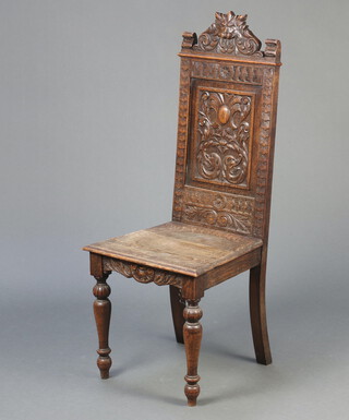 A Victorian carved oak high back hall chair with solid seat raised on turned supports 116cm h x 46cm w x 44cm d 
