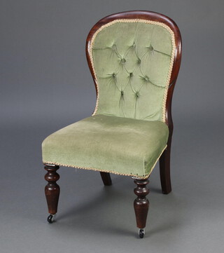 A Victorian mahogany show frame nursing chair, the seat and back upholstered in green buttoned material, raised on turned supports 77cm h x 45cm w x 43cm d 