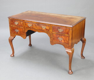 A 1920's Queen Anne style quarter veneered and feather crossbanded writing table fitted a 1 long and 4 short drawers, raised on cabriole supports 77cm h x 121cm w x 58cm d 