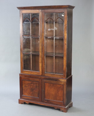 A 19th Century mahogany bookcase on cabinet with moulded cornice, fitted adjustable shelves enclosed by astragal glazed panelled doors, the base fitted a cupboard enclosed by a pair of panelled doors and raised on bracket feet 200cm h x 109cm w x 36cm d 