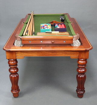 A Victorian mahogany revolving billiards table/dining table with slate base, raised on turned and reeded supports, as billiards table 97cm h x 189cm l x 116cm w, as dining table 80cm high (restored by Sir William Bentley Billiards) together with a set of billiard balls, 15 pool balls, 2 triangles, score board, wall mounting cue rack, brush, 4 cues and a rest 