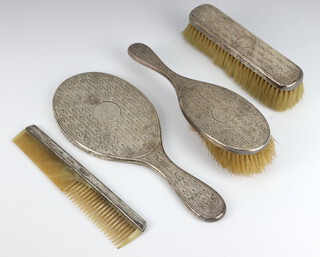 An Edwardian engine turned silver dressing table set comprising hand mirror, hairbrush, clothes brush and comb, Birmingham 1909 