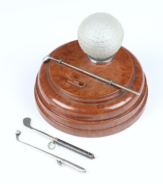An Art Deco Bakelite and plastic table lighter in the form of a golf ball with plated driver, together with 2 novelty golf propelling pencils 