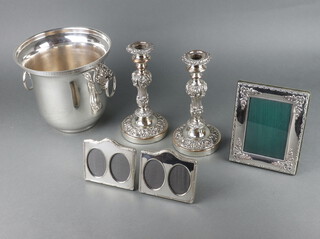 A silver plated champagne cooler, a pair of candlesticks and 3 plated frames 