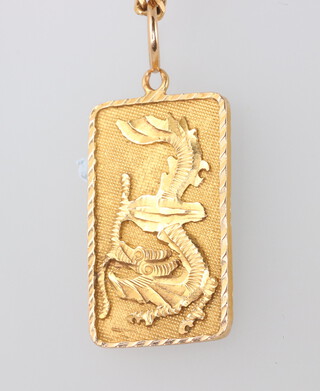 A yellow metal necklace 80cm and pendant decorated with a cockerell and a dragon, 13.8 grams