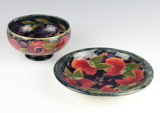 A William Moorcroft shallow dish decorated with pomegranates with signature and impressed mark 22.5cm, a ditto bowl (stuck) 15cm 