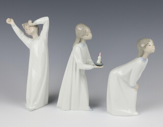 A Lladro figure of a yawning boy 21cm, ditto of a bending girl 18cm and another of a girl holding a chamber stick 22cm 