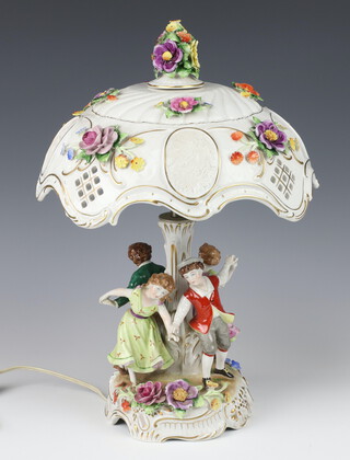 A 20th Century German porcelain table lamp with applied flowers and children dancing at its base 40cm 