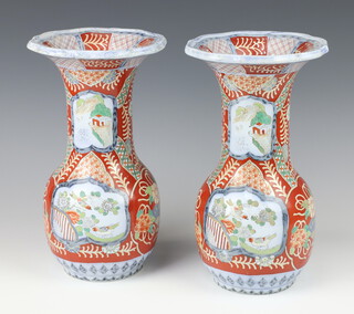 A pair of Victorian English Imari style baluster vases decorated with panels of flowers and buildings 29cm 