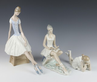 A Nao figure of a reclining ballerina 22cm, a Spanish figure of a seated ballerina 25cm and a Nao figure of a ballerina sitting on a stool 32cm 