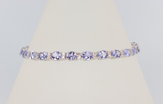 A white metal 18k tanzanite and diamond line bracelet, the tanzanites 8.85ct, the brilliant cut diamonds 0.6ct, 18cm, 7.8 grams 