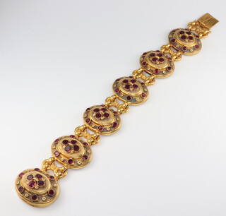 A mid Victorian brass and garnet set 6 plaque bracelet 19cm, the backs are inlaid with mother of pearl panels (one panel a/f)