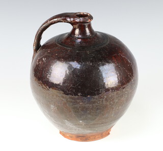 An 18th Century English slip glazed bottle of globular form with narrow neck and simple handle 28cm