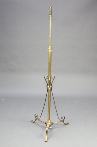 A brass standard lamp raised on a tripod base 142cm h x 53cm 