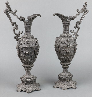 A pair of Victorian cast spelter ewers with mask decoration, raised on panelled feet 40cm h x 20cm w x 10cm d 