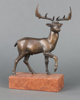 An Art Deco style bronze figure of a walking stag raised on a pink veined marble base 27cm x 18cm x 8cm 