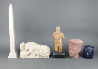 A carved stone obelisk 54cm h x 9cm x 9cm (some chips in places), a rectangular carved stone figure of a lion 16cm x 30cm x 10cm (f and r), a resin figure of a standing male 31cm h, a resin head and shoulders bust of a Pharaoh 18cm h, ditto 12cm h 