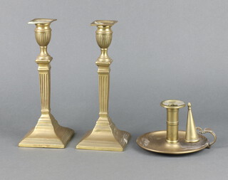 A pair of Adam style reeded brass candlesticks on square bases with detachable sconces 26cm h x 10cm w x 10cm d together with a brass chamberstick with snuffer 10cm h 