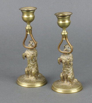 A pair of 19th Century gilt metal candlesticks in the form of standing dogs, raised on circular bases 16cm x 6cm 