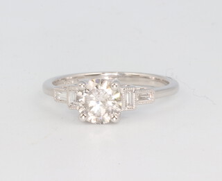 An 18ct white gold single stone diamond ring 0.91ct, supported by baguette cut diamonds 0.12ct, size L, 2.6 grams  together with a WGI certificate 