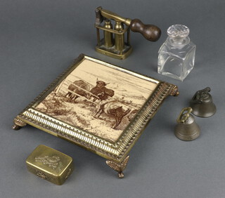 A Victorian ceramic and brass square teapot stand raised on bracket feet 4cm x 19cm x 19cm, a brass bullet mould 8cm x 6cm x 4cm, a Japanese brass box with hinged lid 2cm x 5cm x 4cm, 2 small brass bells and a square glass inkwell 7cm h 