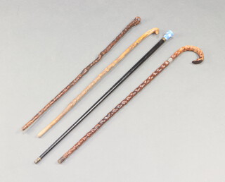 An ebonised walking cane with porcelain terminal, 2 holly walking sticks and 1 other 
