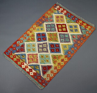 An orange, green, brown and blue ground Chobi Kilim rug with diamond decoration to the centre 136cm x 89cm 