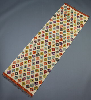 A white, tan and green ground Chobi kilim runner with all over geometric designs 198cm x 63cm 