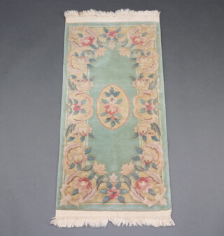 A green ground and floral pattern Chinese rug with central medallion 118cm x 60cm 
