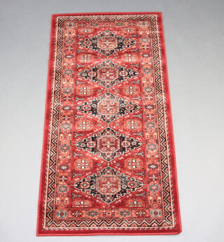 A brown and black ground Persian style machine made rug with 5 stylised medallions to the centre 162cm x 80cm  