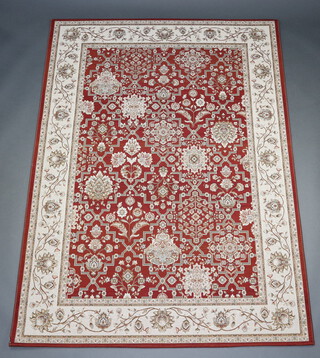 A tan and white ground Aubusson style machine made rug with floral design to the centre 213cm x 155cm 