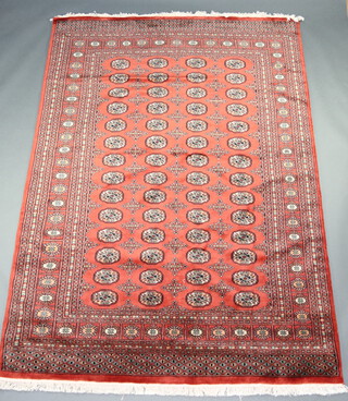 An orange and black ground Bokhara carpet with 84 octagons to the centre 266cm x 186cm
