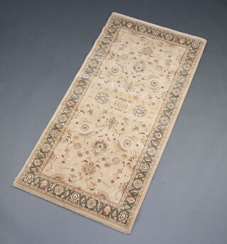 A gold ground and floral patterned Persian style rug 158cm x 80cm 