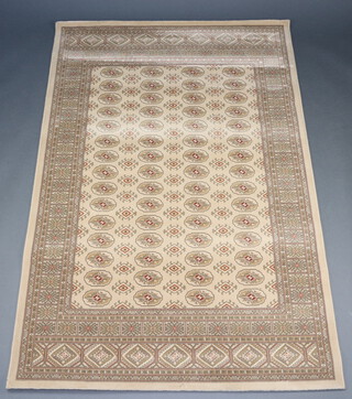 A sand ground machine made Bokhara style rug with 72 medallions to the centre 201cm x 133cm 