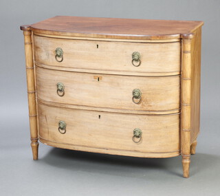 A William IV bleached mahogany bow front chest of 3 drawers with brass ring drop  handles and turned columns to the sides, 89cm h x 110cm w x 55cm d  