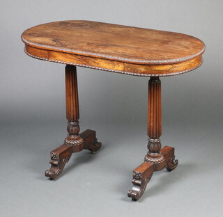 A William IV oval rosewood writing table fitted a drawer, raised on turned and reeded supports with scroll feet 71cm h x 93cm w x 48cm d  
