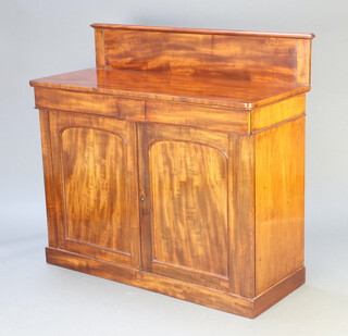A Victorian mahogany chiffonier with raised back, fitted 2 drawers above cupboard enclosed by a panelled door, raised on a platform base 116cm h x 124cm w x 51cm d 