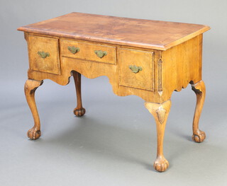A 1920's Queen Anne style quarter veneered walnut and crossbanded low boy with canted corners, fitted 1 long and 2 short drawers, raised on cabriole ball and claw supports, 76cm h x 104cm w x 54cm d 