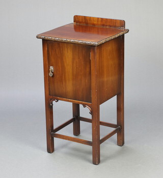 Waring and Gillow, a Chippendale style mahogany bedside cabinet with raised back, cupboard enclosed by a panelled door, raised on square supports with box framed stretcher 81cm h x 41cm w x 38cm d 