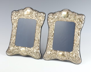 A pair of Victorian style repousse silver photograph frames with scroll decoration, Sheffield 1994, 22cm 