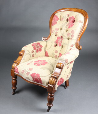 A Victorian mahogany show frame armchair upholstered in floral buttoned material, on turned supports 102cm h x 66cm w x 75cm d (seat 32cm x 36cm) 