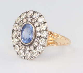 A yellow metal oval sapphire and diamond cluster ring the centre stone 1.11ct the brilliant cut diamonds 1.5ct, 4.2grams, size N