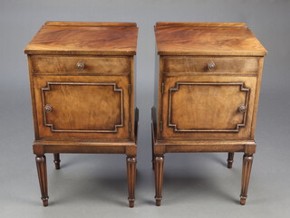 A pair of Georgian style mahogany bedside cabinets with raised backs, above drawer and cupboard enclosed by a panelled door, raised on turned and fluted supports 73cm h x 41cm w x 33cm d 