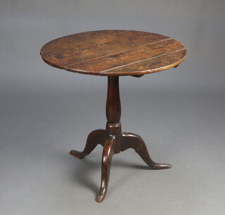 An 18th Century circular oak snap top tea table raised on a turned column and tripod base 66cm h x 66cm w 