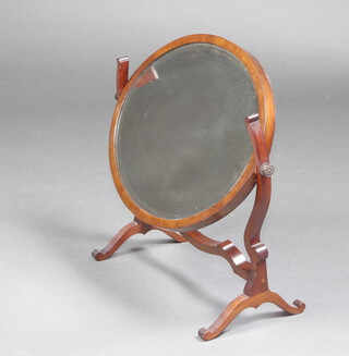 A 19th Century oval bevelled plate dressing table mirror contained in a mahogany swing frame 57cm x 46cm x 24cm d 