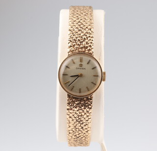A lady's 9ct yellow gold Omega wristwatch and bracelet contained in a 16mm case, the case stamped 7115645, the movement stamped 484, 23.3 grams including the glass, boxed 