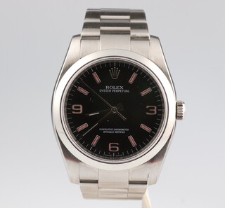 A gentleman's steel cased Rolex Oyster perpetual wristwatch no.878J2466 model 116000, with black dial and pink Arabic numbers 3, 6 and 9, pink batons, the case 34mm, on a Rolex bracelet, it has an International Guarantee, 2 booklets, a pouch, box and outer box 