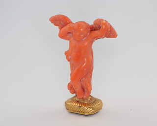 A 19th Century gilt seal with carved amethyst stone (chipped) having a carved coral cherub handle 7cm